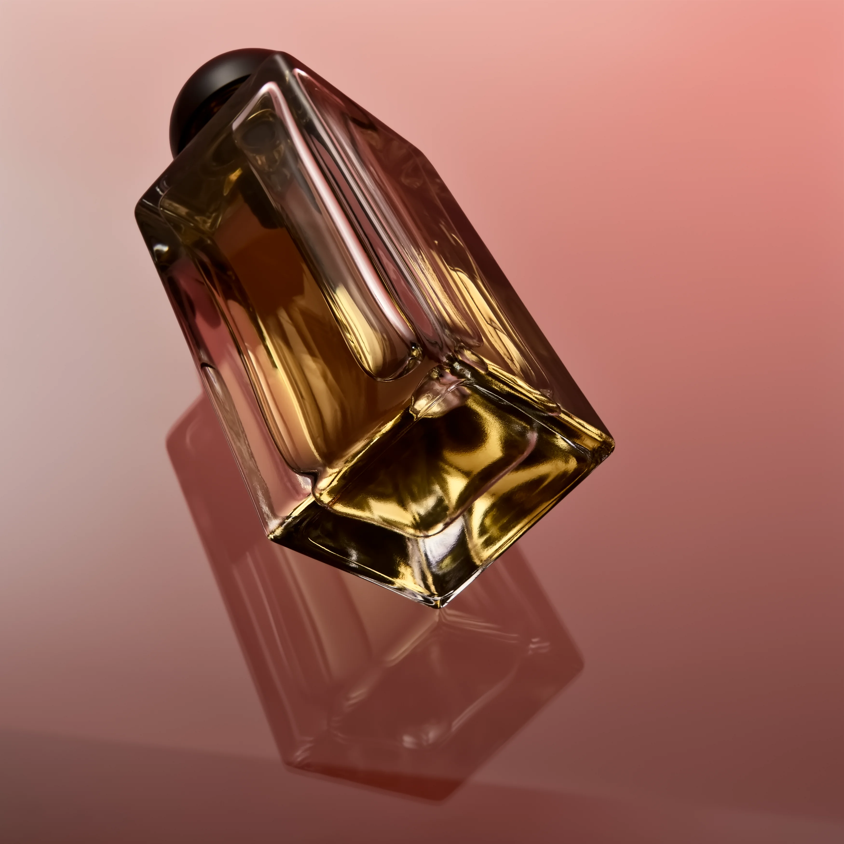 A faceted Maison Noir flacon lit against a coral ground, the amber concentrate visible through the glass
