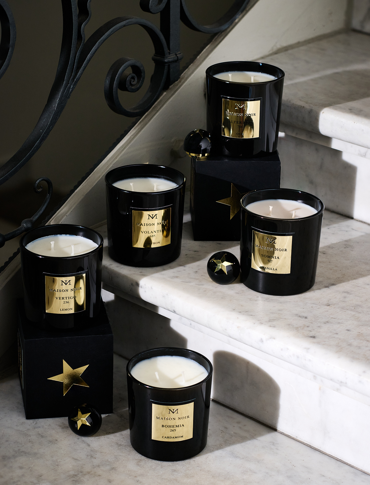 Black and gold candles arranged on the treads of a marble staircase